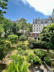 einen Garten vor einem großen Gebäude in der Unterkunft Spacious & modern flat close to Parc Monceau in Paris
