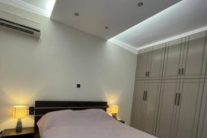 sypialnia z łóżkiem, 2 lampami i sufitem w obiekcie Serenity apartment w mieście Pirgos