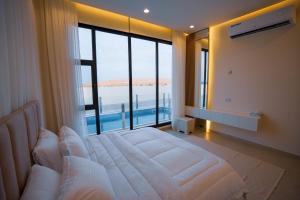 a bedroom with a large white bed and a large window at REMAL INN in Bidiyah