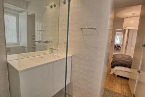 uma casa de banho branca com um lavatório e um chuveiro em Apartamento espaçoso, ideal para famílias - São Bento - TTL339 em Lisboa