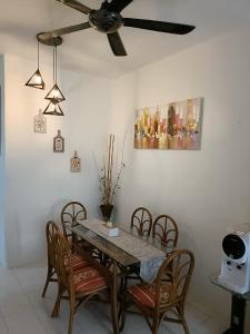 a dining room table with chairs and a ceiling fan at Adempuri homestay in Jitra