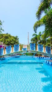 una piscina con azulejos azules y palmeras en Hotel Raices de la Guajira, en Santa Marta