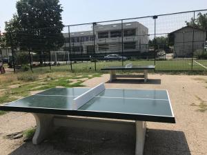 a ping pong table in front of a tennis court at Apartament Langa Plaja Diana in Mangalia