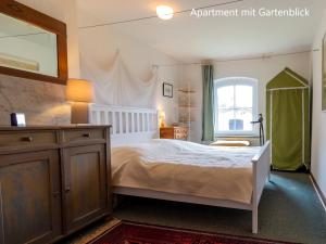 a bedroom with a bed with a dresser and a window at Ferienwohnung im Landhaus Neparmitz in Poseritz