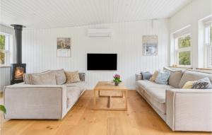 sala de estar con 2 sofás y TV en Cozy Home In Dronningmlle With Kitchen, en Dronningmølle