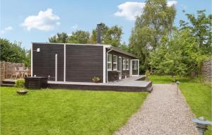 mały domek z tarasem na dziedzińcu w obiekcie Cozy Home In Dronningmlle With Kitchen w mieście Dronningmølle