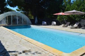 a swimming pool with chairs and an umbrella at Analaya in Vias