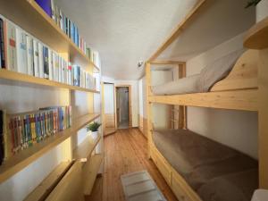 a small room with two bunk beds and bookshelves at tHE Mountain View Lodge in Courmayeur