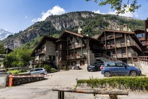 a large building with cars parked in a parking lot at tHE Mountain View Lodge in Courmayeur