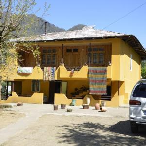 ein gelbes Haus mit einem Handtuch auf der Vorderseite in der Unterkunft Guest House Machakheli in Batumi