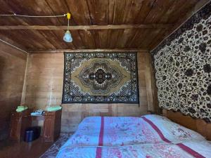 Schlafzimmer mit einem Bett mit Wandteppich in der Unterkunft Guest House Machakheli in Batumi