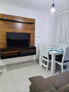 salon ze stołem i telewizorem w obiekcie Aline Duque Residence w mieście Porto de Galinhas