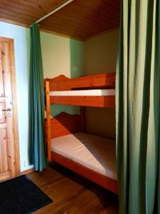 2 Etagenbetten in einem Zimmer mit grünen Vorhängen in der Unterkunft Ekhems Gård in Förslöv