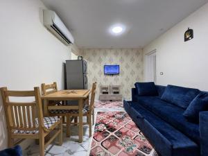 a living room with a blue couch and a table at شاليه في بورتو السخنه منتجع Chalet Porto el sokhna Heaven hills عائلات فقط H in Ain Sokhna