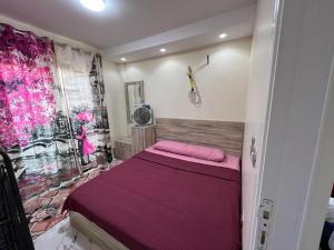 a bedroom with a bed with a purple blanket at شاليه في بورتو السخنه منتجع Chalet Porto el sokhna Heaven hills عائلات فقط H in Ain Sokhna +10 photos