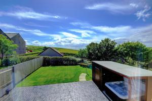 uma vista para um jardim a partir da varanda de uma casa em Aurora - Self Catering, Kirkwall, Quiet Location with Luxury Hot Tub em Orkney