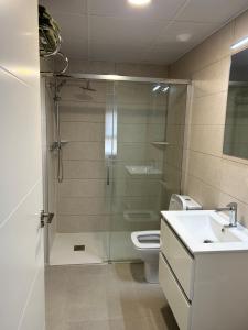 Un baño con ducha, inodoro y lavabo. en Apartamentos Bretón 17 Double Deluxe, en Alicante