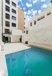 una piscina frente a un edificio en Apartamentos Bretón 17 Double Deluxe, en Alicante