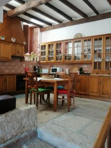 a kitchen with wooden cabinets and a table and chairs at Casa do Lagar in Almeida
