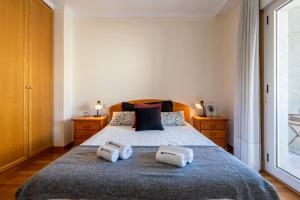 een slaapkamer met een bed met twee handdoeken erop bij Homely Fresh Apartment - Terrace & Garage in Póvoa de Varzim