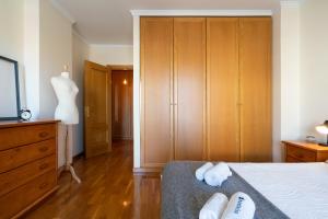 een slaapkamer met een bed en een dressoir met handdoeken bij Homely Fresh Apartment - Terrace & Garage in Póvoa de Varzim