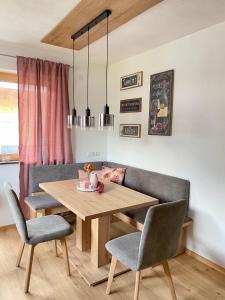 a dining room with a wooden table and chairs at Apart Alpenherz in Schwendau