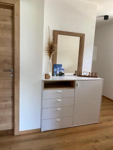 Vestidor blanco con espejo en una habitación en Apart Alpenherz, en Schwendau
