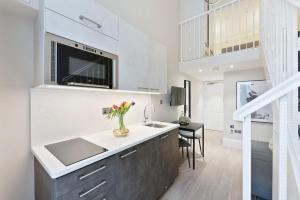 a kitchen with a sink and a vase of flowers at Cleveland Residences Kensington in London