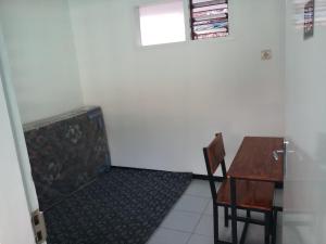 Zimmer mit einem Schreibtisch, einem Tisch und einem Stuhl in der Unterkunft Welirang 20B Homestay - Max 2 Orang Per Kamar in Malang