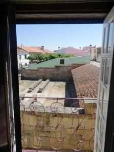 a view from a window of a courtyard with benches at Casa do Lagar in Almeida +13 photos