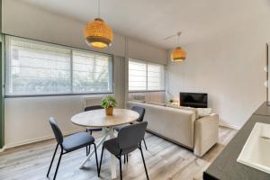 ein Wohnzimmer mit einem Tisch, Stühlen und einem Sofa in der Unterkunft Le Général Appartement proche des quais ! in Rouen