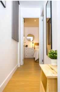a hallway leading to a bedroom with a bed and a mirror at Exyca Cuatro Caminos in Madrid