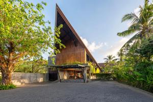 Kayumas Seminyak Resort في سمينياك: مبنى خشبي كبير مع سقف مقامر