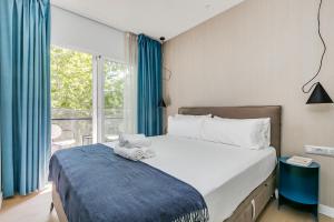 een slaapkamer met een bed en een groot raam bij Home Art Apartments Chamberí in Madrid