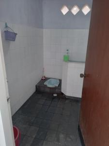 ein Bad mit WC in einem gefliesten Zimmer in der Unterkunft Welirang 20B Homestay - Max 2 Orang Per Kamar in Malang