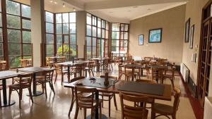 a restaurant with tables and chairs and windows at Hotel y Cabañas Huallilemu Sur - Caja Los Andes in El Quisco