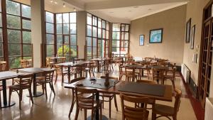 un ristorante con tavoli, sedie e finestre di Hotel y Cabañas Huallilemu Sur - Caja Los Andes a El Quisco