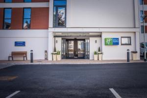 a building with a door with a bench in front of it at Holiday Inn Express - Exeter - City Centre, an IHG Hotel in Exeter