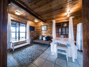a living room with a white table and a refrigerator at Oyster Creek Lodge in Knysna