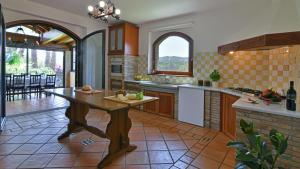 eine große Küche mit einem Tisch in der Mitte in der Unterkunft VILLA BIDDIZZA 8, Emma Villas in Acireale