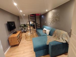 uma sala de estar com um sofá azul e uma televisão em Maison Malo-Lina à 350m de la plage de Malo les bains em Dunkerque