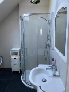 La salle de bains blanche est pourvue d'une douche et d'un lavabo. dans l'établissement Spanko, à Sztutowo