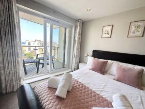 a bedroom with a large bed and a large window at 6 Ocean Views in Newquay