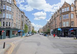 an empty street in a city with tall buildings at The Marchmont Residence in Edinburgh
