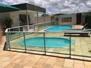 zwei Schwimmbecken auf einer Terrasse mit einem Gebäude in der Unterkunft Apartamento em Mossoró in Mossoró + 3 Fotos