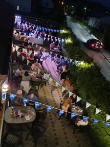 a group of people sitting at a restaurant at night at Saaler Pfandl Ferienwohnung zentral gelegen in Saal