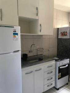 a kitchen with a white refrigerator and a sink at Apartamento em Mossoró in Mossoró
