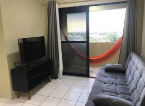 ein Wohnzimmer mit Sofa und Flachbildfernseher in der Unterkunft Apartamento em Mossoró in Mossoró