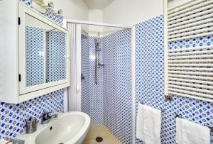 un bagno blu e bianco con lavandino e doccia di Acquaviva 31 a Capri