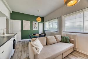 ein Wohnzimmer mit einem Sofa und einem Tisch in der Unterkunft Le Général Appartement proche des quais ! in Rouen